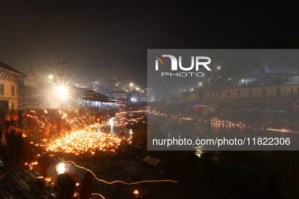 A long exposure shot shows lights set to float in the Bagmati River by Hindu devotees in Kathmandu, Nepal, on November 30, 2024, during the...