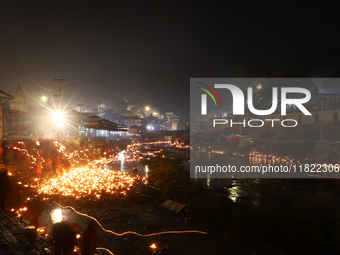 A long exposure shot shows lights set to float in the Bagmati River by Hindu devotees in Kathmandu, Nepal, on November 30, 2024, during the...