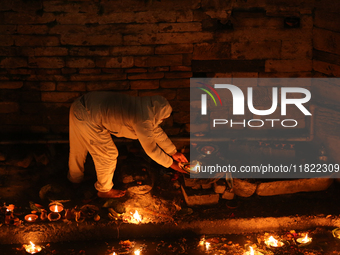 A Nepali Hindu devotee lights oil-fed lamps on the embankment of the Bagmati River in Kathmandu, Nepal, on November 30, 2024, on the occasio...