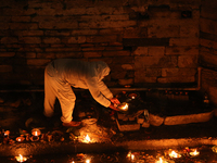 A Nepali Hindu devotee lights oil-fed lamps on the embankment of the Bagmati River in Kathmandu, Nepal, on November 30, 2024, on the occasio...