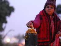 A Nepali Hindu devotee offers ''Sat-bij,'' seven sacred seeds, to a Shivalinga (Idol of Lord Shiva) in the premises of Pashupatinath Temple...