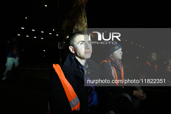 Members of the Ostatnie Pokolenie or Last Generation group block traffic on the Wybrzeze Gdanskie street in Warsaw, Poland on 27 November, 2...