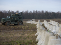 A military vehicle stands guard next to anti-tank concrete fortifications at the Polish-Russian border in Dabrowka, Poland, on November 30,...