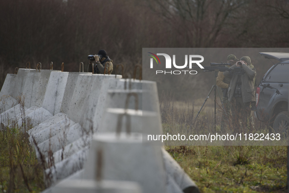 Polish Border Guard members stand guard next to anti-tank concrete fortifications before Polish Prime Minister Donald Tusk's press conferenc...