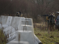 Polish Border Guard members stand guard next to anti-tank concrete fortifications before Polish Prime Minister Donald Tusk's press conferenc...