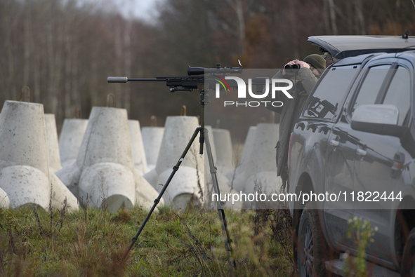 Polish Border Guard members stand guard next to anti-tank concrete fortifications before Polish Prime Minister Donald Tusk's press conferenc...