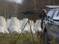 Polish Border Guard members stand guard next to anti-tank concrete fortifications before Polish Prime Minister Donald Tusk's press conferenc...