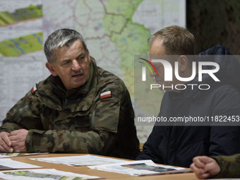 Gen. Marek Wawrzyniak (left) talks to the Polish PM Donald Tusk (right) during a briefing at the Polish-Russian border in Dabrowka, Poland,...