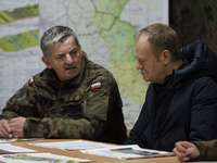 Gen. Marek Wawrzyniak (left) talks to the Polish PM Donald Tusk (right) during a briefing at the Polish-Russian border in Dabrowka, Poland,...