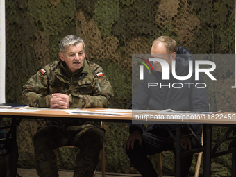 Gen. Marek Wawrzyniak (left) talks to the Polish PM Donald Tusk (right) during a briefing at the Polish-Russian border in Dabrowka, Poland,...