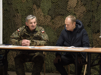 Gen. Marek Wawrzyniak (left) talks to the Polish PM Donald Tusk (right) during a briefing at the Polish-Russian border in Dabrowka, Poland,...