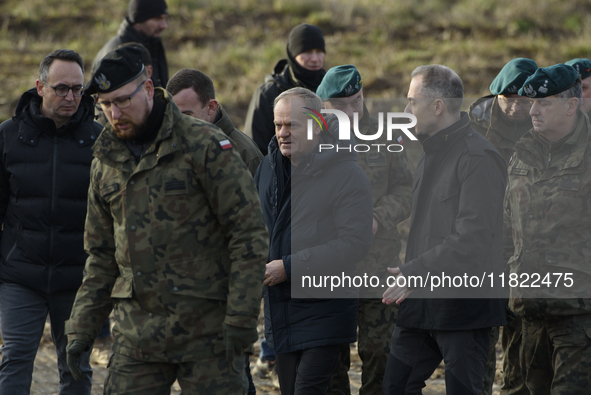 Polish Prime Minister Donald Tusk (center left) and Deputy Minister of National Defense Cezary Tomczyk (center right) talk before a press co...