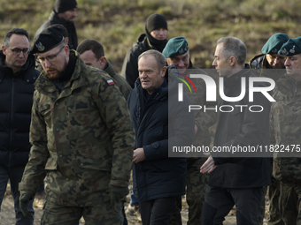 Polish Prime Minister Donald Tusk (center left) and Deputy Minister of National Defense Cezary Tomczyk (center right) talk before a press co...