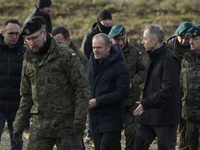 Polish Prime Minister Donald Tusk (center left) and Deputy Minister of National Defense Cezary Tomczyk (center right) talk before a press co...