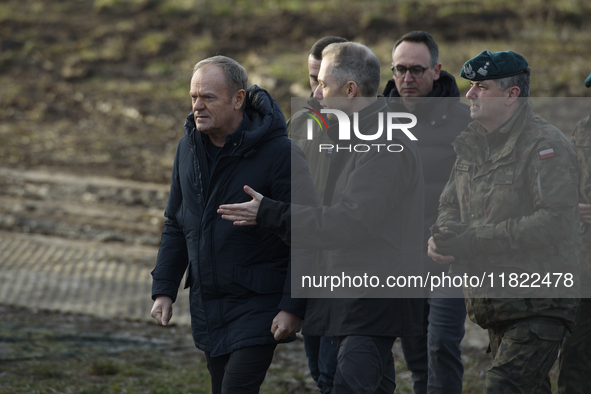 Polish Prime Minister Donald Tusk (center left) and Deputy Minister of National Defense Cezary Tomczyk (center right) talk before a press co...