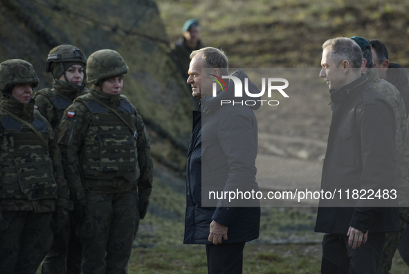 Polish Prime Minister Donald Tusk (center left) and Deputy Minister of National Defense Cezary Tomczyk (center right) talk before a press co...