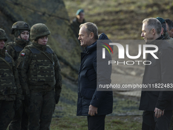 Polish Prime Minister Donald Tusk (center left) and Deputy Minister of National Defense Cezary Tomczyk (center right) talk before a press co...