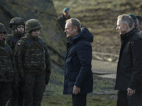 Polish Prime Minister Donald Tusk (center left) and Deputy Minister of National Defense Cezary Tomczyk (center right) talk before a press co...