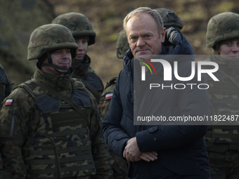 Polish Prime Minister Donald Tusk visits members of the Polish armed forces at the Polish-Russian border in Dabrowka, Poland, on November 30...