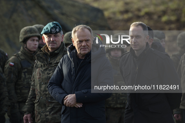 Polish Prime Minister Donald Tusk (left) and Deputy Minister of National Defense Cezary Tomczyk (right) talk before a press conference in Da...