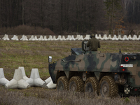 A Polish armed forces vehicle stands guard next to anti-tank concrete fortifications at the Polish-Russian border in Dabrowka, Poland, on No...