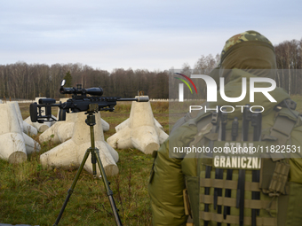 Polish Border Guard members stand guard next to anti-tank concrete fortifications before Polish Prime Minister Donald Tusk's press conferenc...