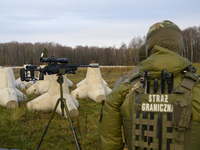 Polish Border Guard members stand guard next to anti-tank concrete fortifications before Polish Prime Minister Donald Tusk's press conferenc...