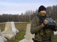 A Polish Border Guard soldier uses thermal vision binoculars as he stands guard next to anti-tank concrete fortifications before Polish Prim...