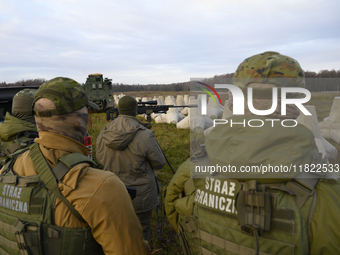 Polish Border Guard members stand guard next to anti-tank concrete fortifications before Polish Prime Minister Donald Tusk's press conferenc...