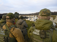 Polish Border Guard members stand guard next to anti-tank concrete fortifications before Polish Prime Minister Donald Tusk's press conferenc...