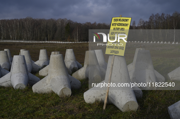 A warning sign lies against anti-tank concrete fortifications at the Polish-Russian border in Dabrowka, Poland, on November 30, 2024. The Ea...