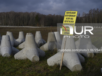 A warning sign lies against anti-tank concrete fortifications at the Polish-Russian border in Dabrowka, Poland, on November 30, 2024. The Ea...