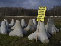 A warning sign lies against anti-tank concrete fortifications at the Polish-Russian border in Dabrowka, Poland, on November 30, 2024. The Ea...