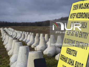 A warning sign lies against anti-tank concrete fortifications at the Polish-Russian border in Dabrowka, Poland, on November 30, 2024. The Ea...