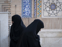 Two veiled Iranian women walk past each other at a mosque in northeastern Tehran, Iran, on November 30, 2024. (