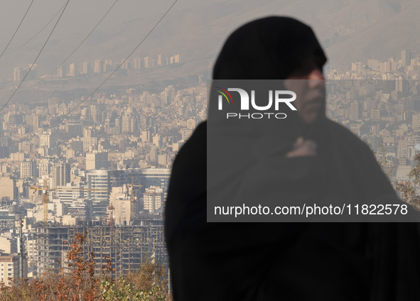 A view of Tehran as a veiled Iranian woman participates in a funeral in northeastern Tehran, Iran, on November 30, 2024. 