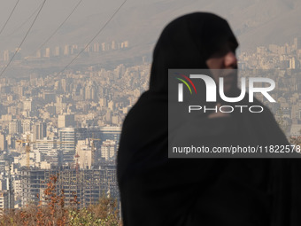 A view of Tehran as a veiled Iranian woman participates in a funeral in northeastern Tehran, Iran, on November 30, 2024. (