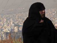 A view of Tehran as a veiled Iranian woman participates in a funeral in northeastern Tehran, Iran, on November 30, 2024. (