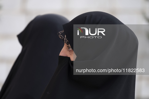 Two veiled Iranian women participate in a funeral in northwestern Tehran, Iran, on November 30, 2024. 