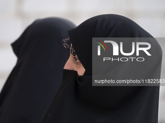 Two veiled Iranian women participate in a funeral in northwestern Tehran, Iran, on November 30, 2024. (