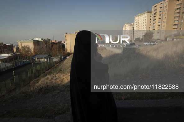 A veiled Iranian woman stands in a residential area in northeastern Tehran, Iran, on November 30, 2024. 