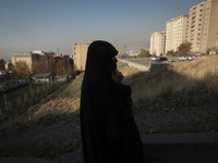 A veiled Iranian woman stands in a residential area in northeastern Tehran, Iran, on November 30, 2024. (