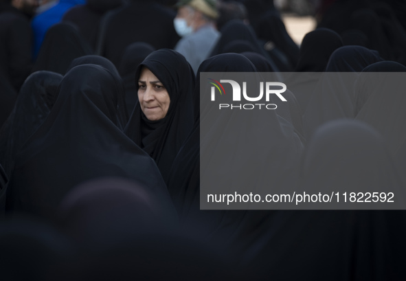 A veiled Iranian woman looks on while participating in a funeral in northwestern Tehran, Iran, on November 30, 2024. 