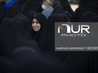 A veiled Iranian woman looks on while participating in a funeral in northwestern Tehran, Iran, on November 30, 2024. (