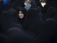 A veiled Iranian woman looks on while participating in a funeral in northwestern Tehran, Iran, on November 30, 2024. (