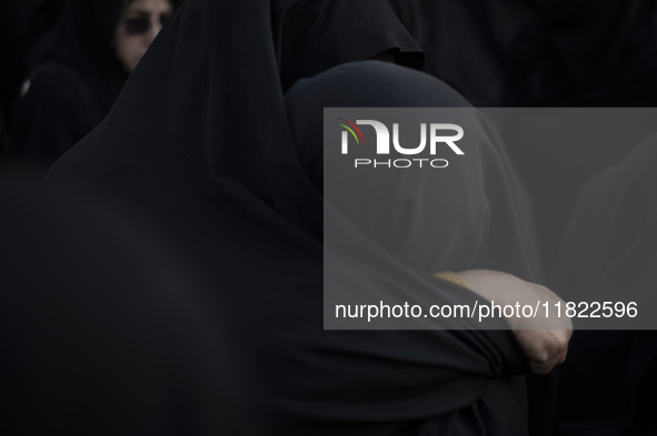 Two veiled Iranian women hug each other while participating in a funeral in northwestern Tehran, Iran, on November 30, 2024. 