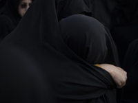 Two veiled Iranian women hug each other while participating in a funeral in northwestern Tehran, Iran, on November 30, 2024. (