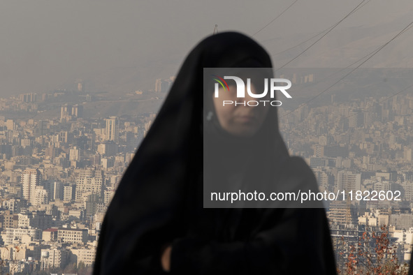 A view of Tehran as a veiled Iranian woman participates in a funeral in northeastern Tehran, Iran, on November 30, 2024. 