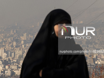 A view of Tehran as a veiled Iranian woman participates in a funeral in northeastern Tehran, Iran, on November 30, 2024. (