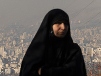 A view of Tehran as a veiled Iranian woman participates in a funeral in northeastern Tehran, Iran, on November 30, 2024. (